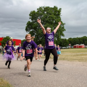 Girls on the Run junior coach is happily running with excited participants